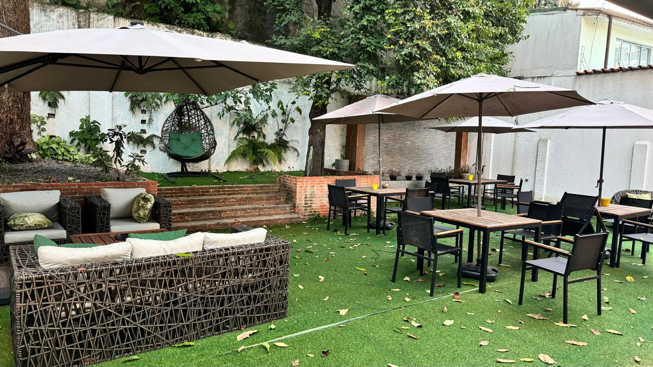 Lounge externo do jardim com sofá redondo de vime e almofadas